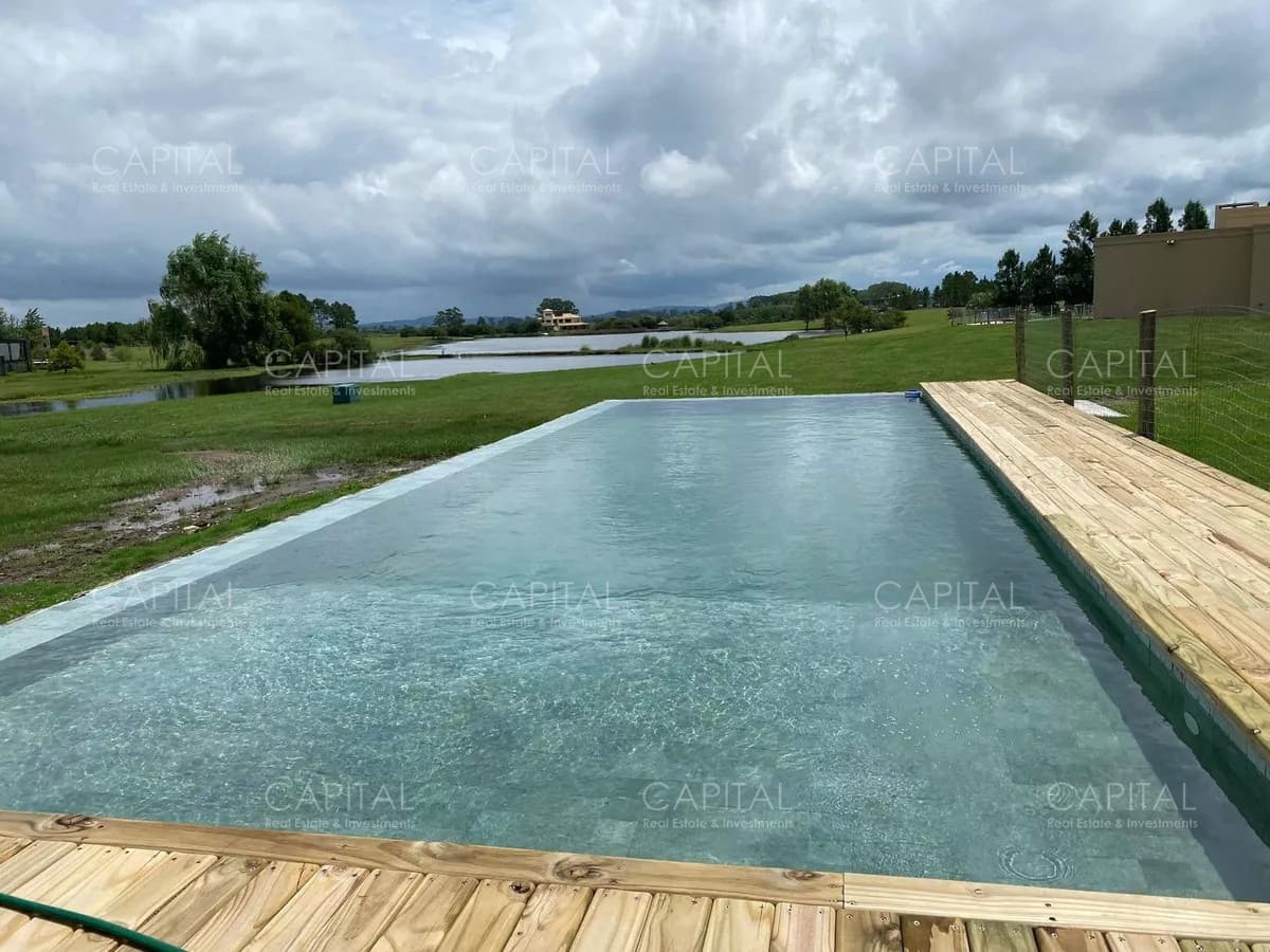 Casa moderna de cuatro dormitorios y dependencia de servicio, parrillero y piscina climatizada en venta en barrio privado El Quijote, La Barra