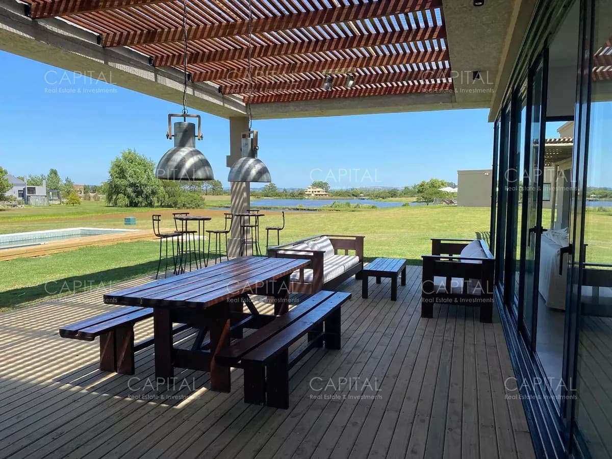 Casa moderna de cuatro dormitorios y dependencia de servicio, parrillero y piscina climatizada en venta en barrio privado El Quijote, La Barra